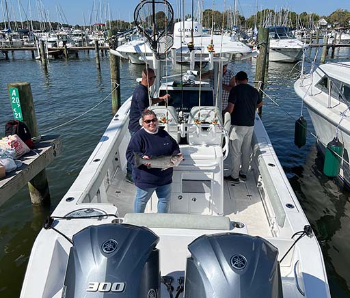 Group of men on Chill's Light Tackle boat with a rockfish at Chesapeake Bay marina